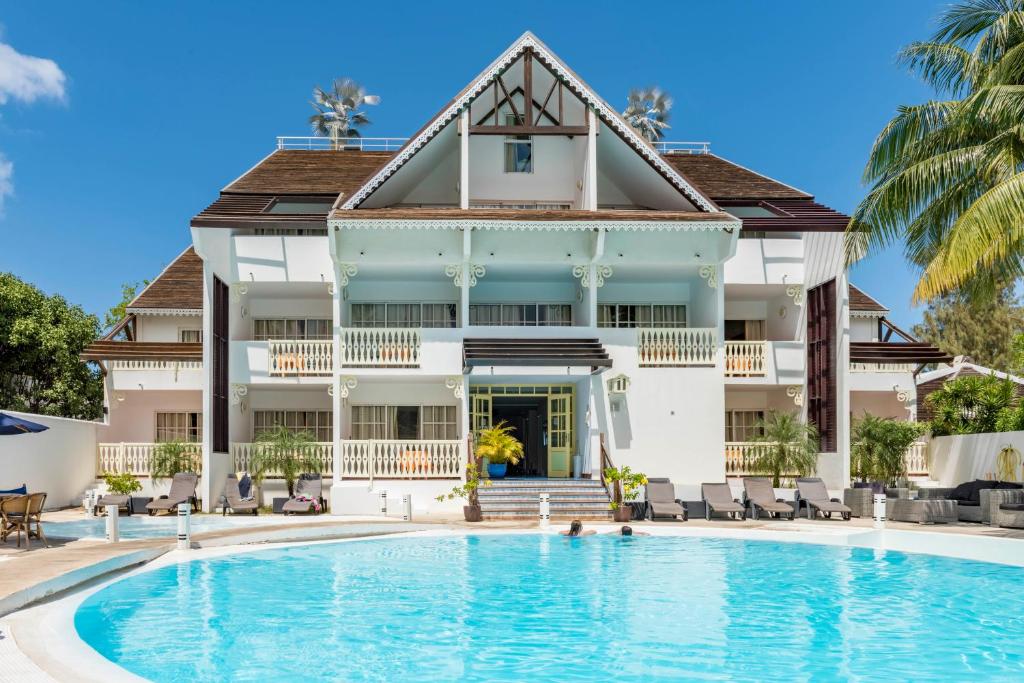 une maison avec une piscine en face d'un bâtiment dans l'établissement Le Nautile Beachfront, à Saint-Gilles les Bains