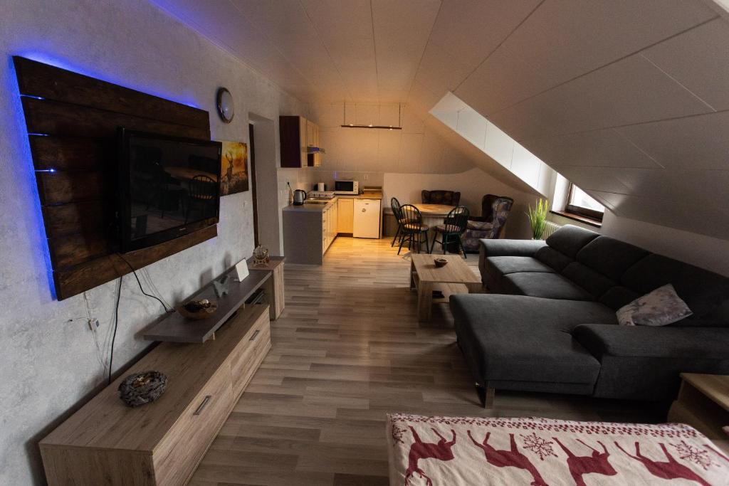 a living room with a couch and a tv at Apartment Vila Božena - Tatranská Lomnica in Tatranská Lomnica