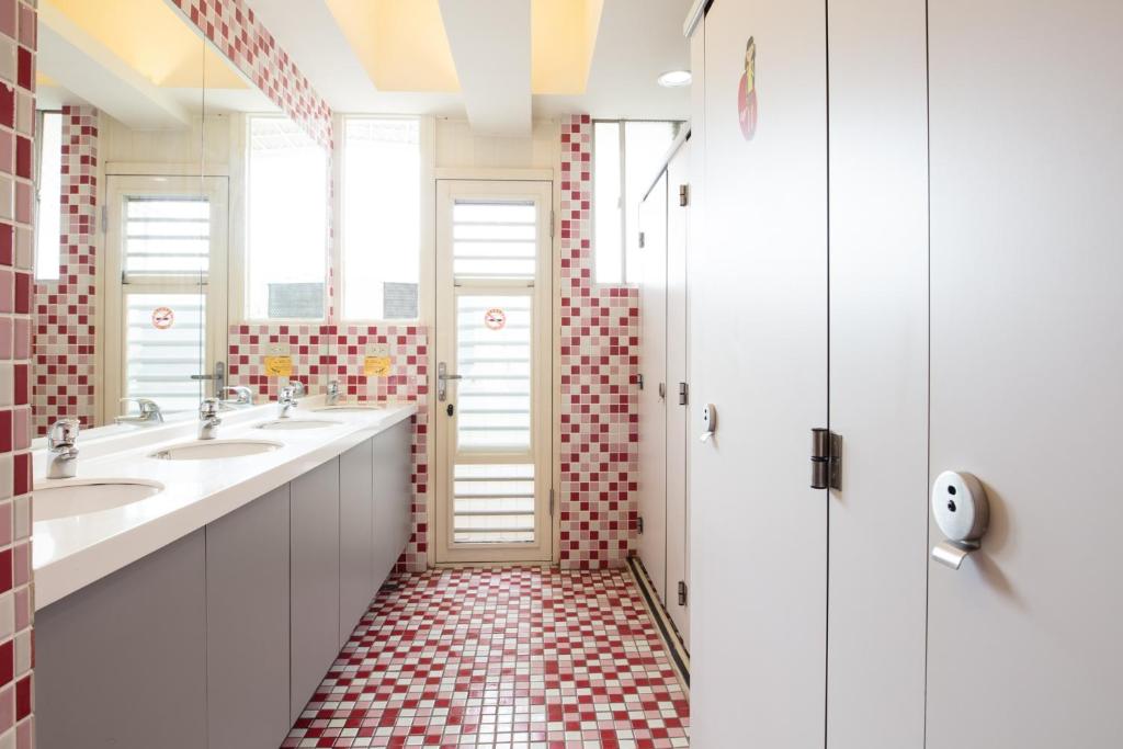 a bathroom with two sinks and red and white tiles at On My Way - Taipei Hostel in Taipei