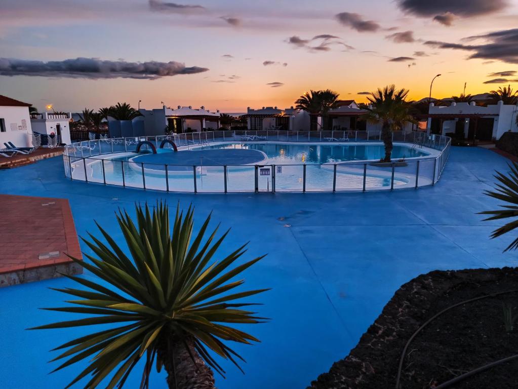 a resort pool with blue water at sunset at Sun Beach 89 in Caleta De Fuste