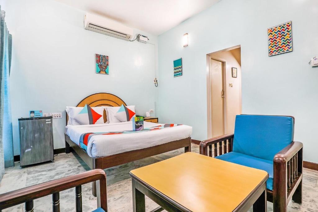a hotel room with a bed and a chair at FabExpress Santhi Inn, Promenade Beach in Pondicherry