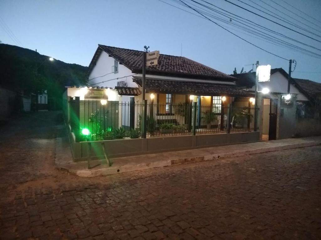 a house with a green light on a street at night at Pousada Amaryllis in Tiradentes