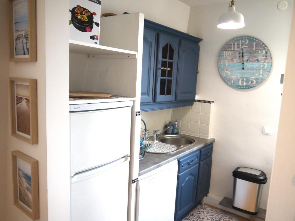 una pequeña cocina con armarios azules y fregadero en Au troisième ciel - 250m de la plage - 6 pers- Berck-sur-Mer, en Berck-sur-Mer