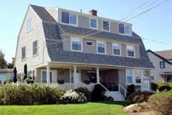 una gran casa blanca con un patio con césped verde en Seafarer Inn en Rockport