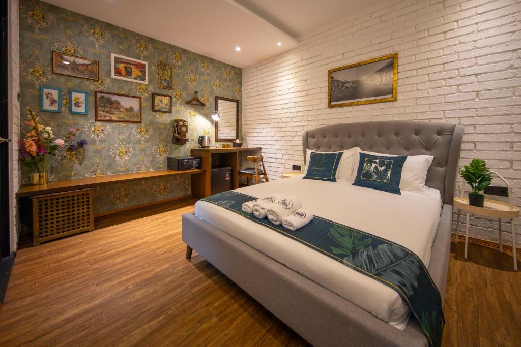 a bedroom with a large bed and a brick wall at Reunion Carnarvon in George Town