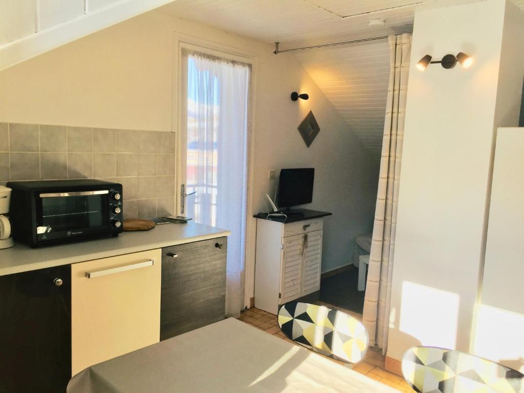 a small kitchen with a counter and a microwave at Location Le Queron in Guillestre