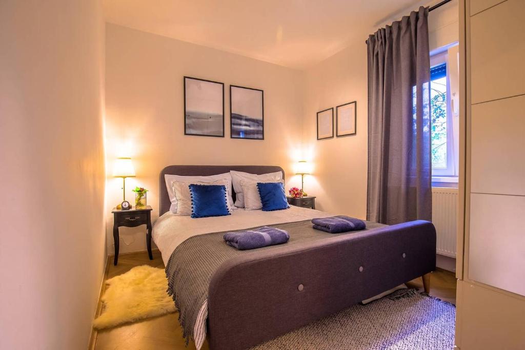 1 dormitorio con 1 cama grande con almohadas azules en Number 28 Boutique Apartment en Zagreb