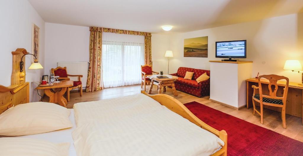 Habitación de hotel con cama y sala de estar. en Harzer Hof, en Herzberg am Harz