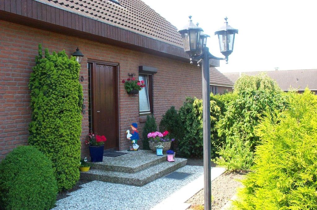 uma casa com um caminho que leva a uma porta em BUUS10101-FeWo-an-de-Bohnscheen em Fehmarn