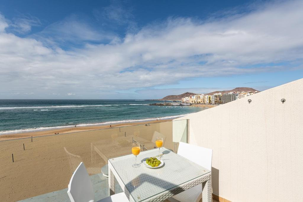 ラスパルマス・デ・グランカナリアにあるBeachfront Home Las Canteras 4 - Sea Views Terraceの白いテーブル(ビーチにグラス2杯付)