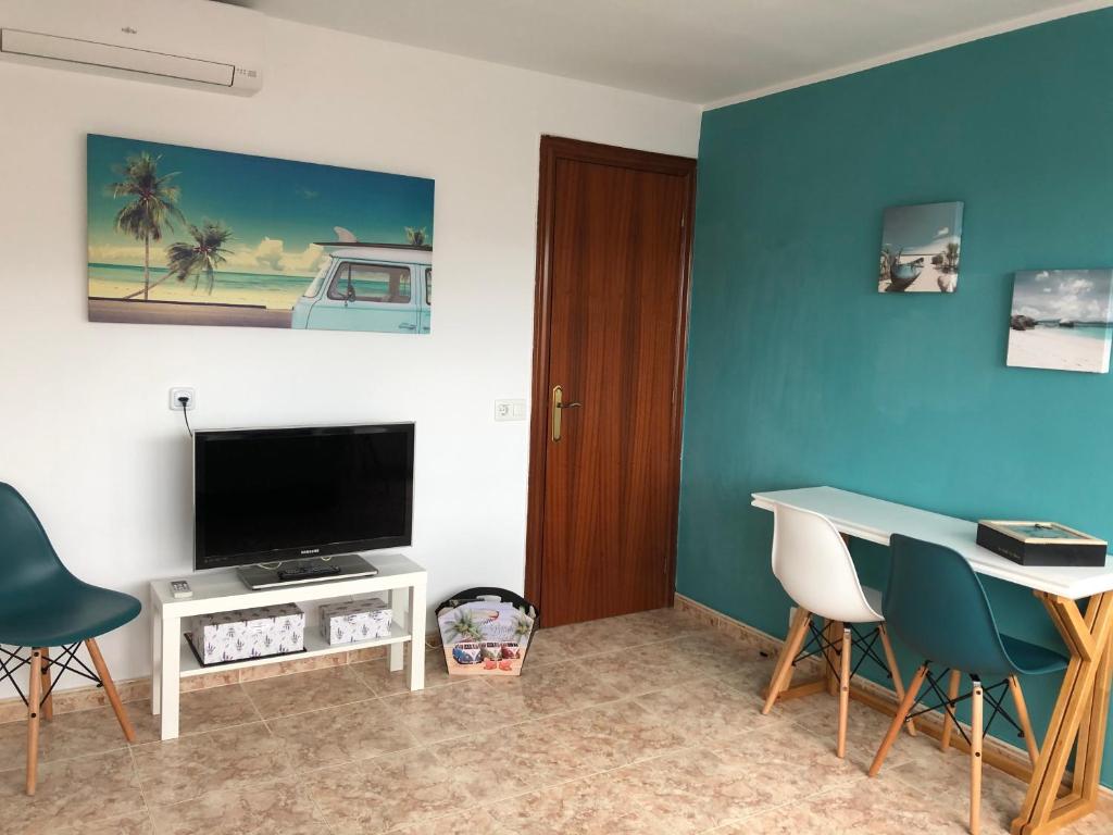 - un salon avec une télévision, une table et des chaises dans l'établissement Beta's place - Apartamento primera línea de playa, à Blanes