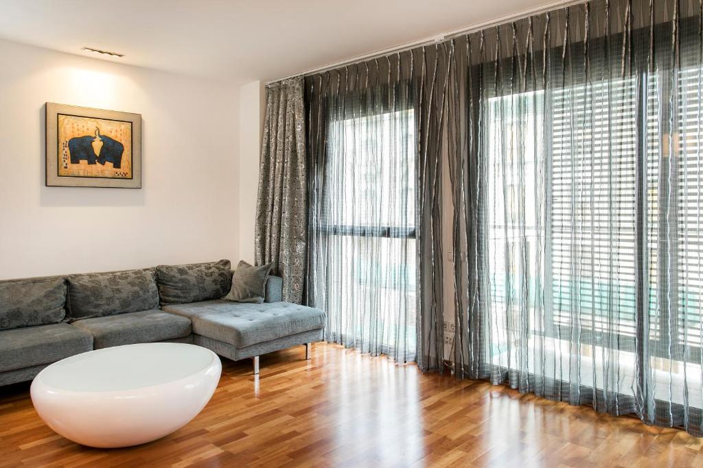 - un salon avec un canapé et une grande fenêtre dans l'établissement Stay U-nique Apartments Plaça de Tetuan, à Barcelone