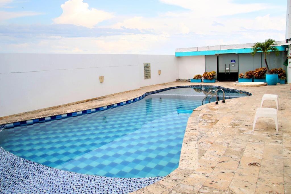 een zwembad in een gebouw met een blauwe bij Ayenda 1801 El Oceano in Cartagena