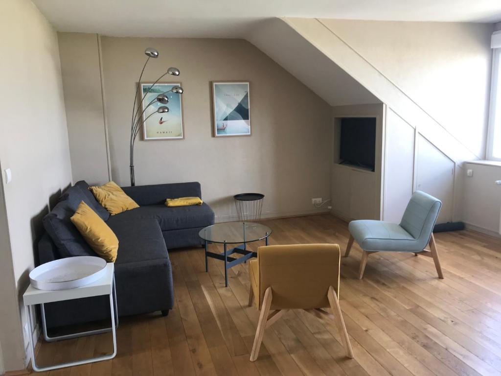 uma sala de estar com um sofá e uma mesa em Sunset Dieppe em Dieppe
