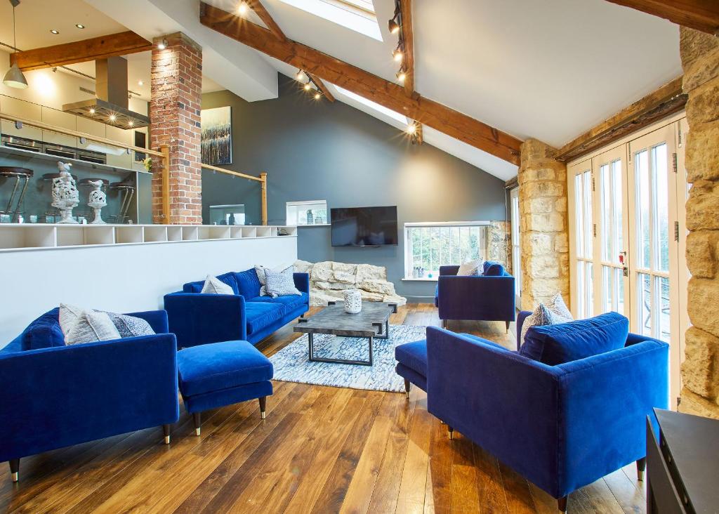 a living room with blue couches and a table at Host & Stay - The Old Pottery in Pickering