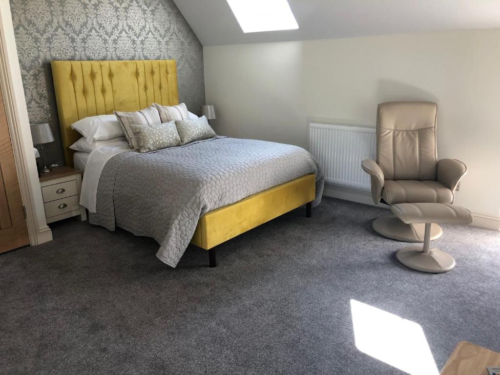 1 dormitorio con 1 cama y 1 silla en Christmas Hill Farm, en Gaydon