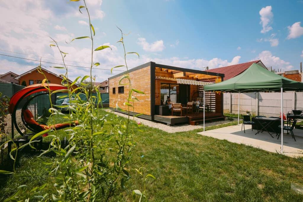une petite maison avec une tente verte dans une cour dans l'établissement Casa Kokopelli, à Oradea