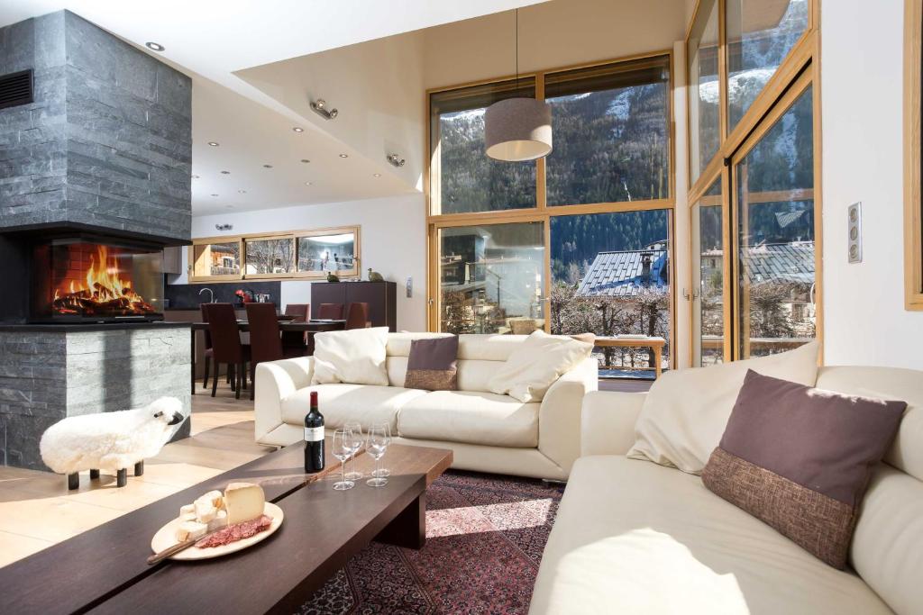 a living room with white furniture and a fireplace at Chalet Couttet - Chamonix All Year in Chamonix