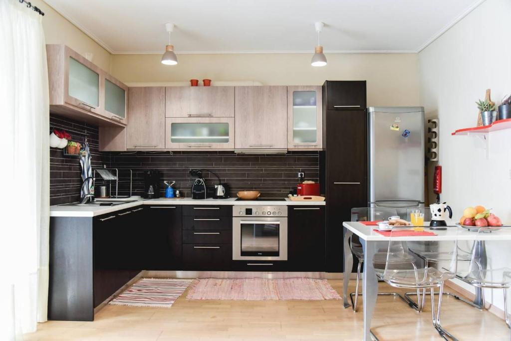 a kitchen with black cabinets and a stainless steel refrigerator at Two bedroom apartment in Kesariani in Athens