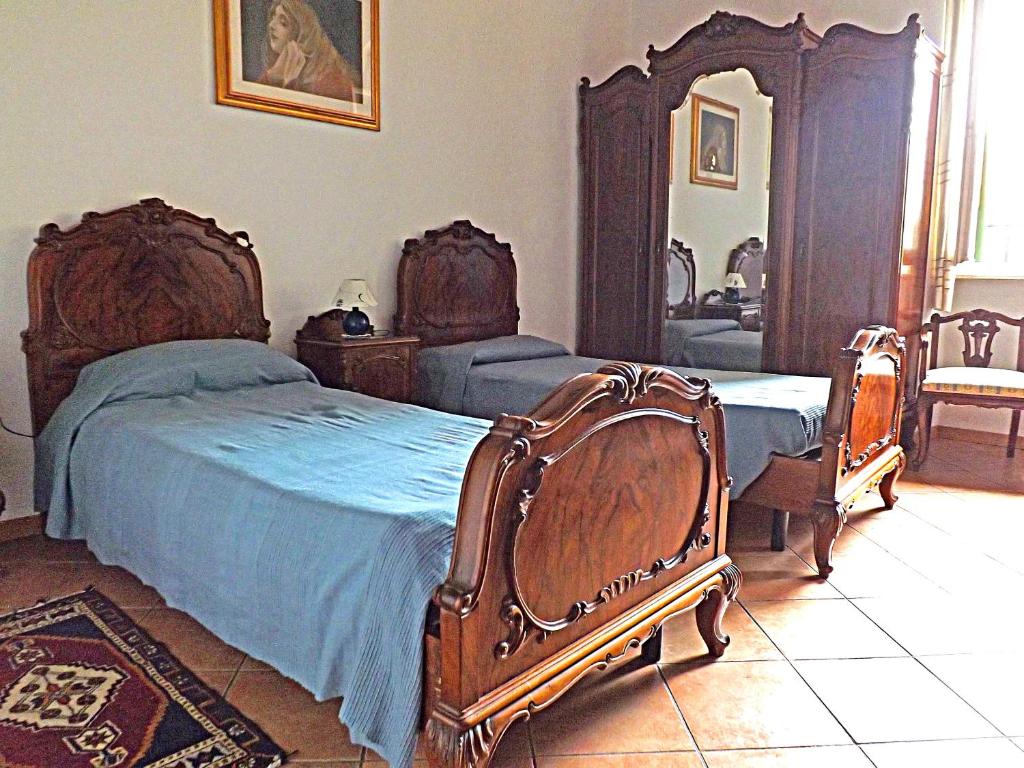 una camera con due letti e uno specchio di Casa Ariodante a Perugia