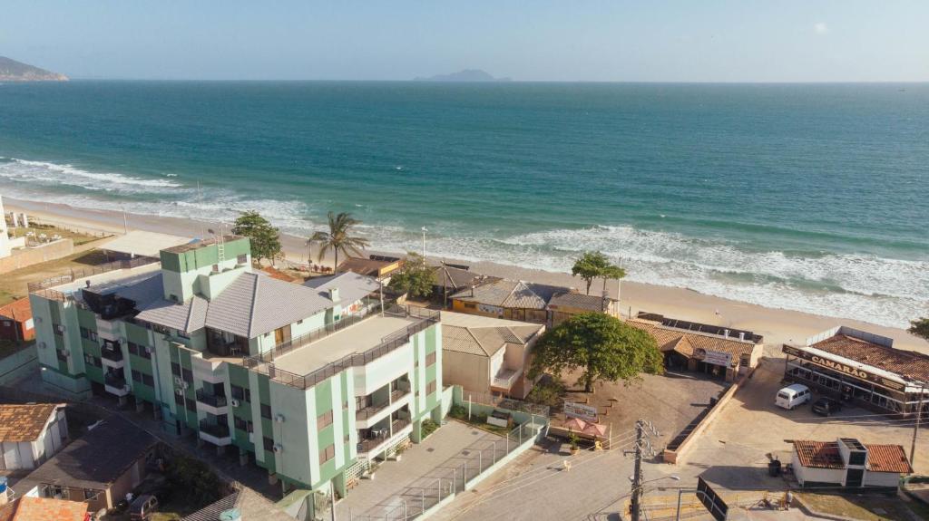 una vista aérea de una playa con un edificio y el océano en Apartamento Condominio Maria Isabel, en Florianópolis