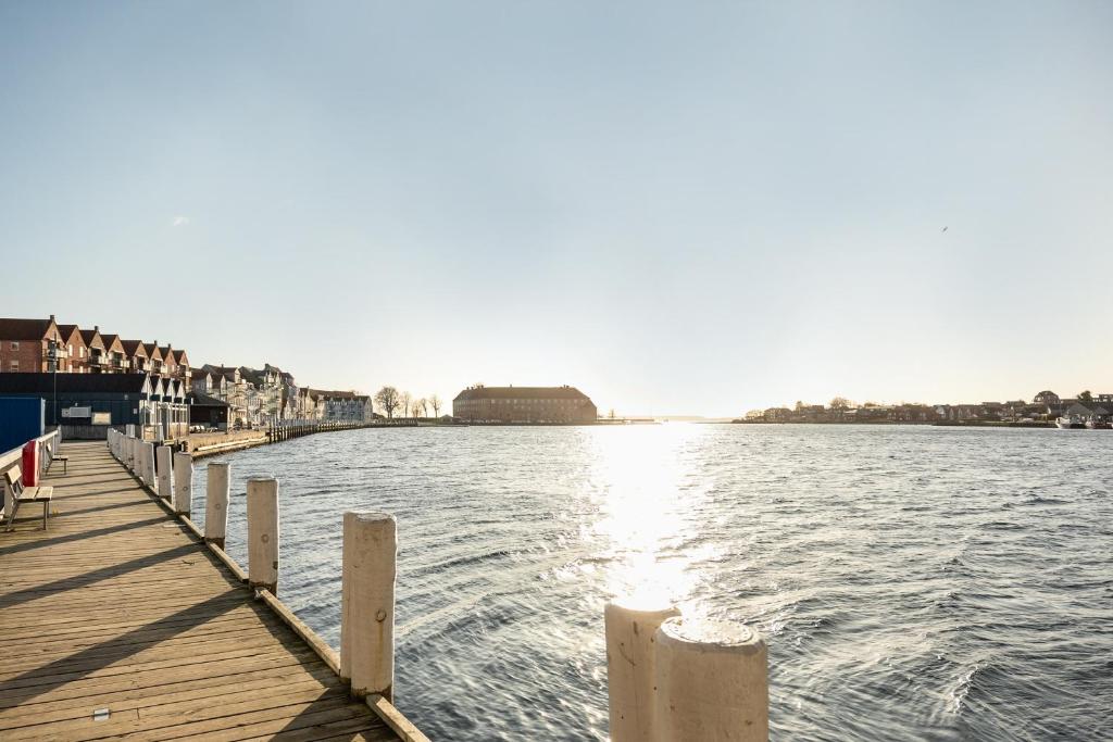 ein Dock auf einem Wasserkörper mit Gebäuden in der Unterkunft Harbour Penthouse in Sønderborg