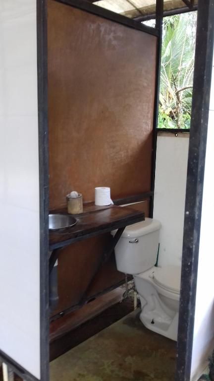 a bathroom with a toilet and a wooden counter at Bolita Trails and Lodging in Dos Brazos