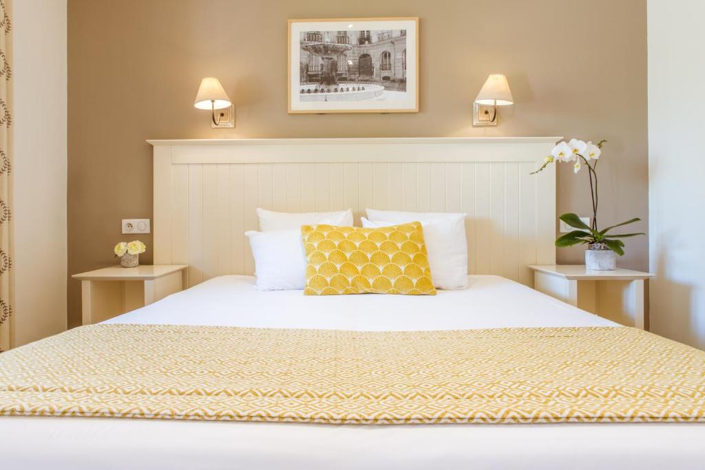 1 dormitorio con cama blanca y almohada amarilla en Le Concorde, en Aix-en-Provence