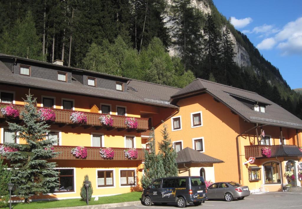 a large building with cars parked in front of it at Hotel Twengerhof in Tweng