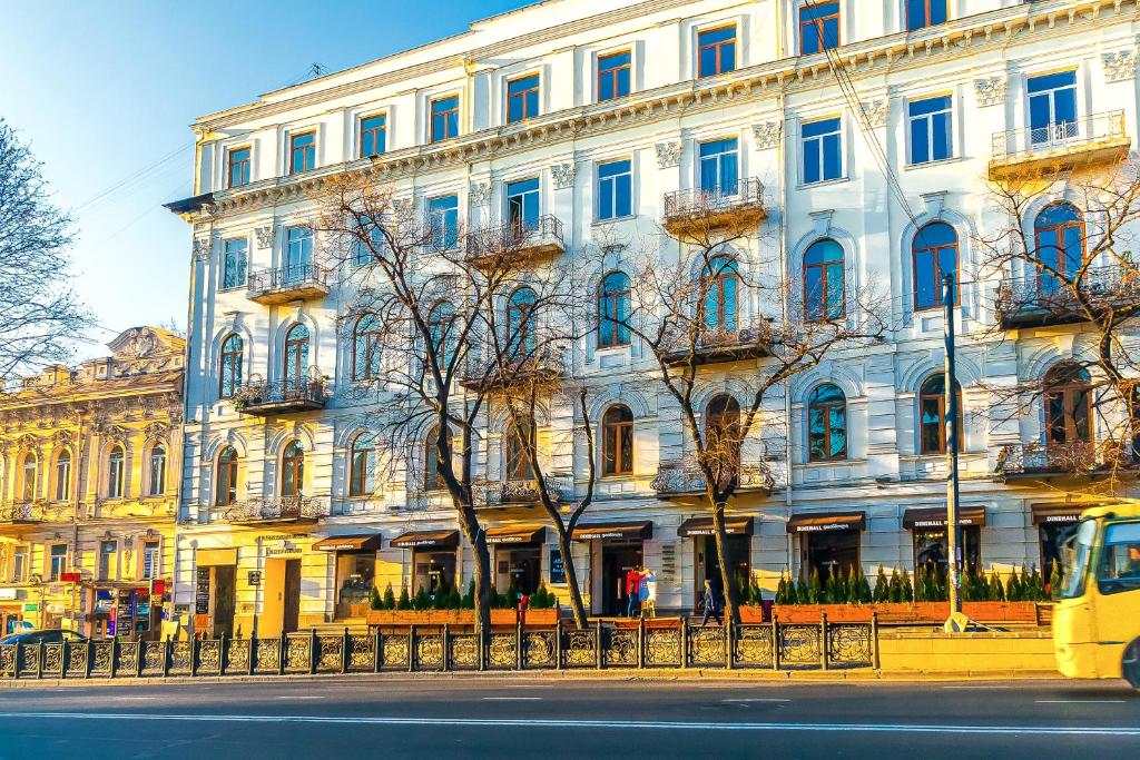 un gran edificio blanco con ventanas azules en una calle en Rustaveli Hotel, en Tiflis