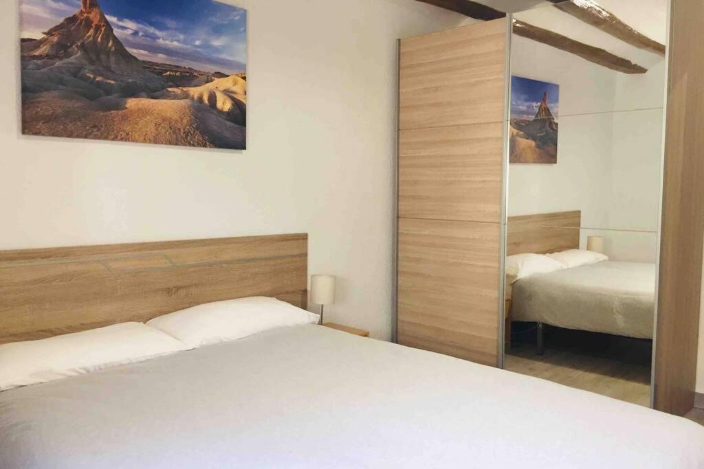 1 dormitorio con 2 camas y espejo en Buenavista Olite, en Olite