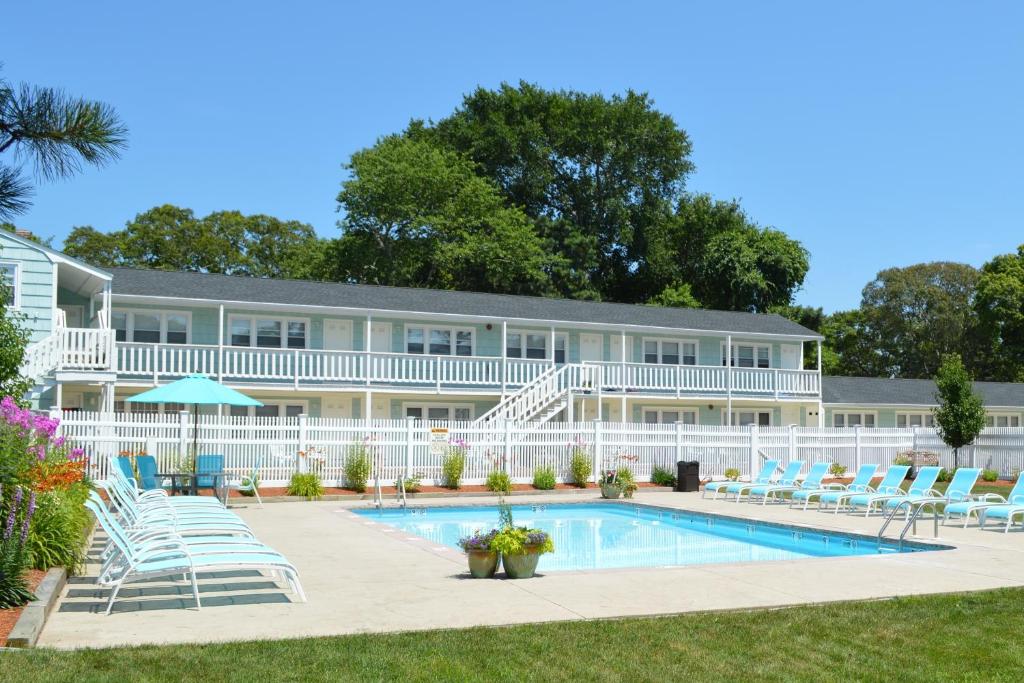 a resort with a swimming pool and lounge chairs at The Escape Inn in South Yarmouth