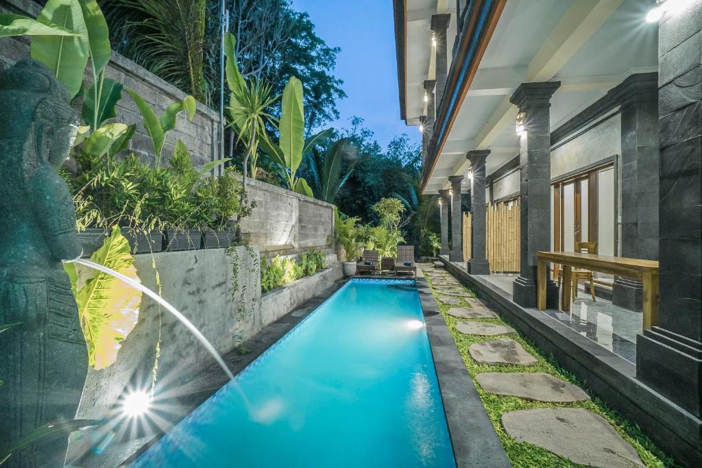 een zwembad in de achtertuin van een huis bij Adenia House Ubud in Ubud