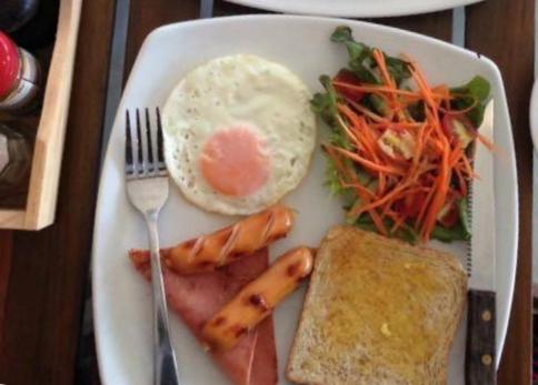a plate of food with eggs bacon carrots and toast at Namm Natawn in Ko Yao Noi