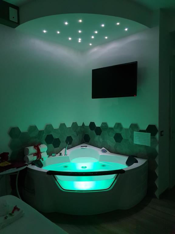 een badkamer met een bad en een tv aan de muur bij Il Mare Di Roma Luxury in Lido di Ostia