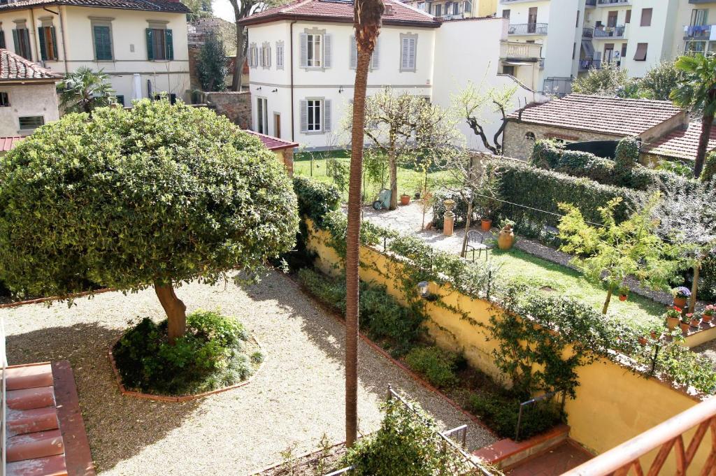 Blick auf einen Garten mit einem Baum und Gebäuden in der Unterkunft Bartolomeo in Florenz