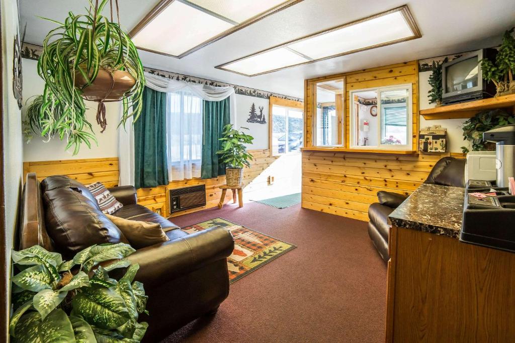 sala de estar con sofá de cuero y mesa en Rodeway Inn Bryce Canyon, en Panguitch