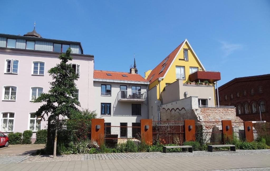 un grupo de edificios con un árbol delante de ellos en Backbord Und Steuerbord, en Stralsund