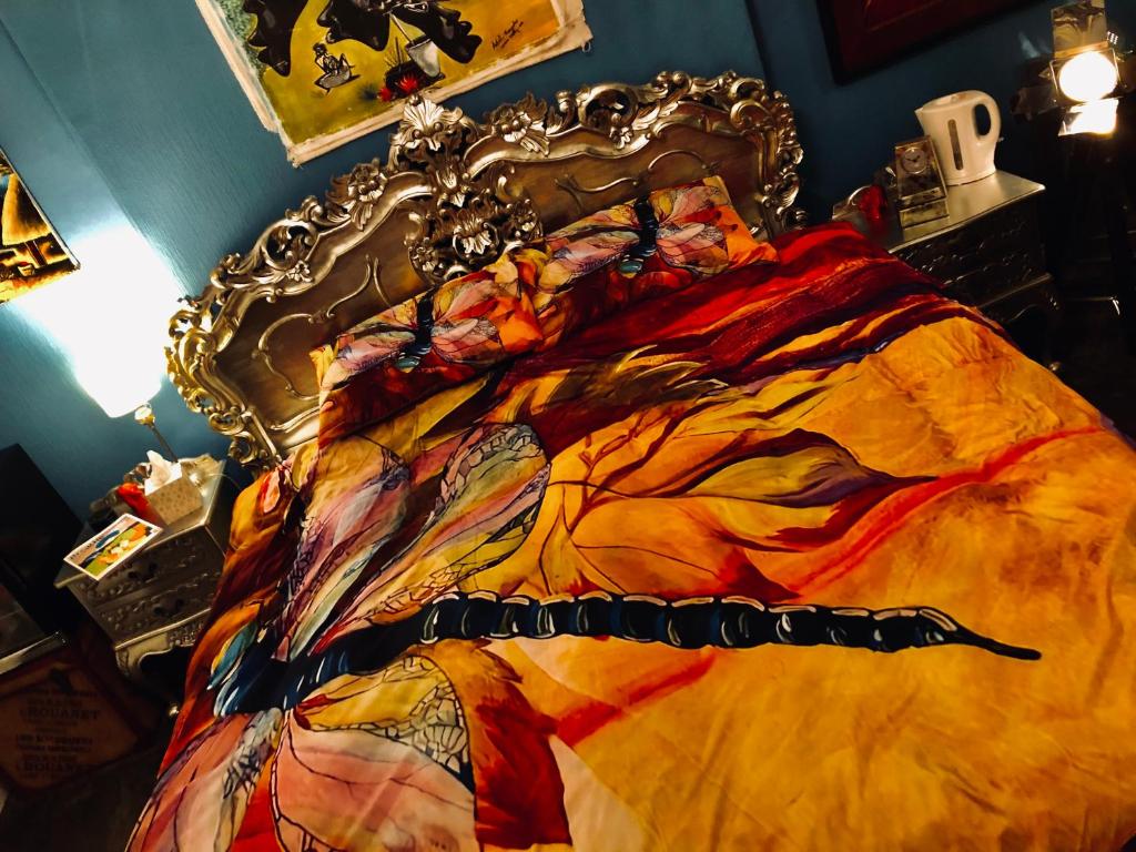 a bed with a colorful blanket on top of it at Belmont House Boutique - the Kingsley collection in Berwick-Upon-Tweed