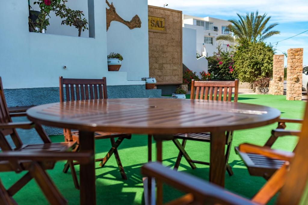 a wooden table and chairs on a patio at Apartamentos Mar y Sal in La Savina