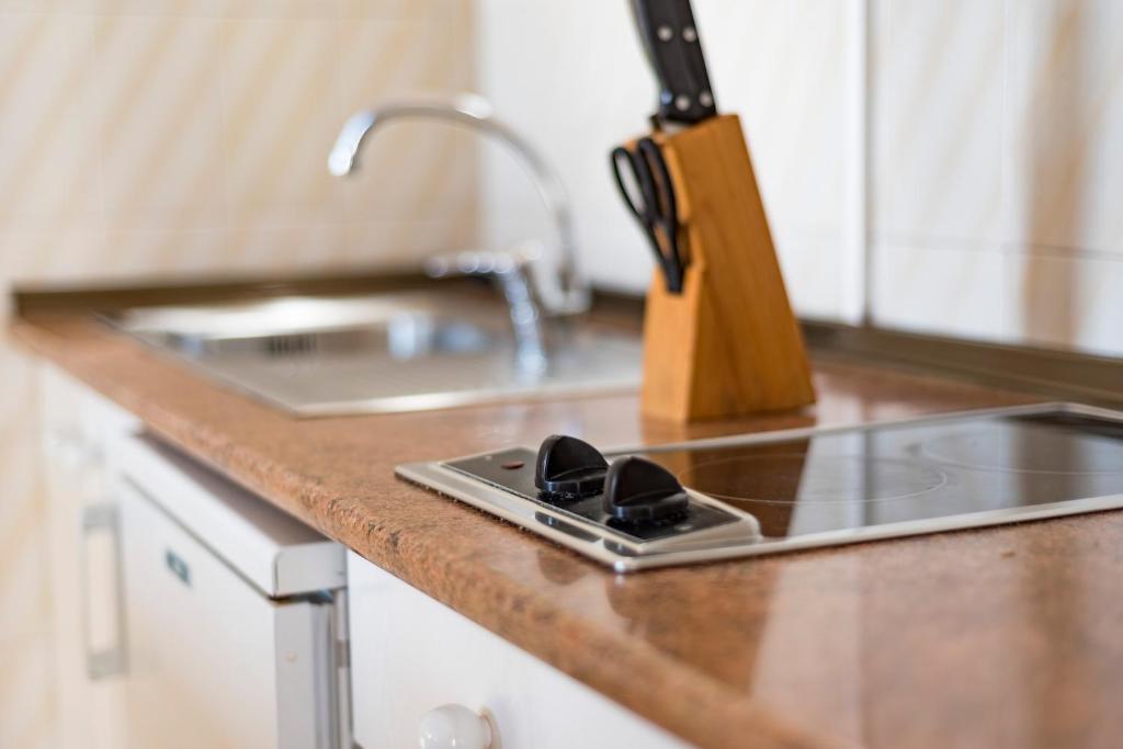a kitchen counter top with a sink and a sink at Apartamentos Mar y Sal in La Savina