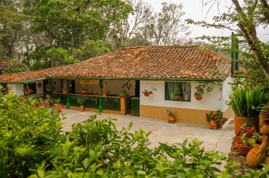 ein Haus mit einem gefliesten Dach und einem Hof in der Unterkunft Finca Sol y Luna in San Gil