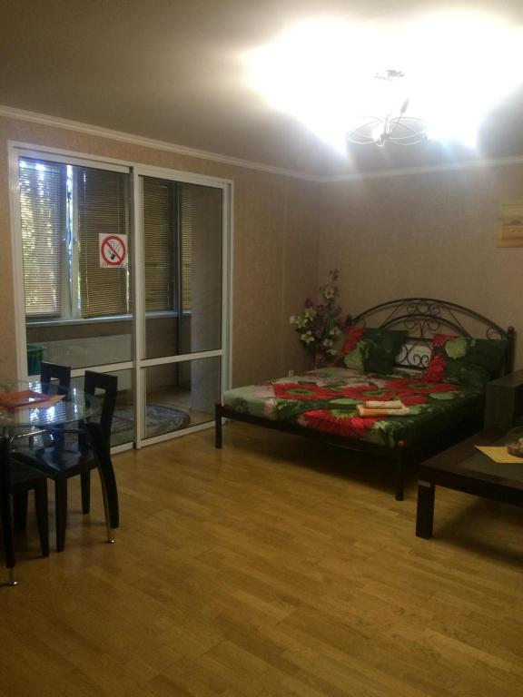 - un salon avec un lit et une table dans l'établissement 1 комнатная квартира студио возле ТРЦ Днепроплаза, à Tcherkassy