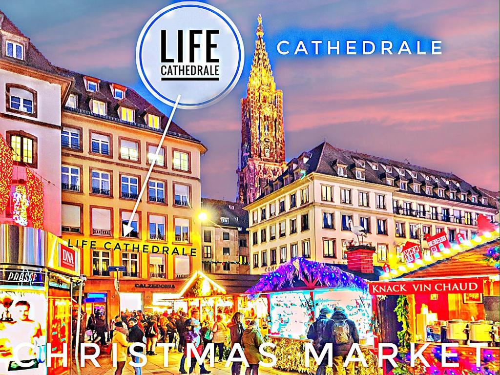 uma cidade com um mercado de Natal com uma torre de relógio em LIFE CATHEDRALE City-Center Place Gutenberg em Estrasburgo