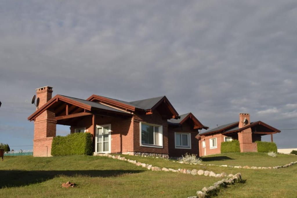 una casa en una colina con un patio de hierba en Complejo Yantes en Villa Giardino