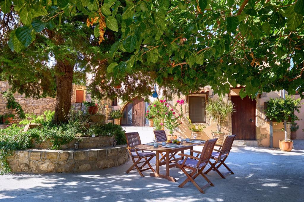 una mesa y sillas bajo un árbol en un patio en Mouri Villa en Mouríon