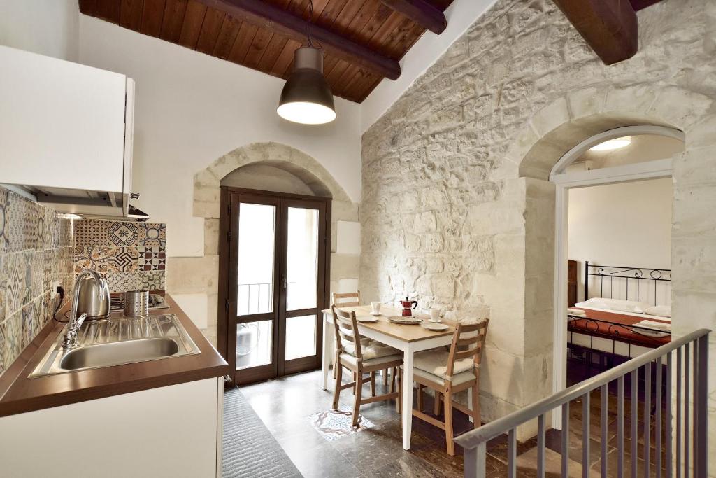 a kitchen with a table and a dining room at Suite Piccolo Giavante in Ragusa