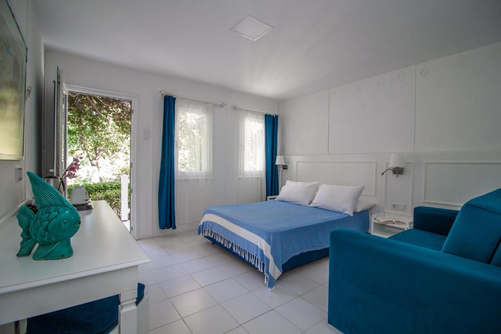 a bedroom with a blue bed and a blue couch at Blue & White Hotel in Cıralı