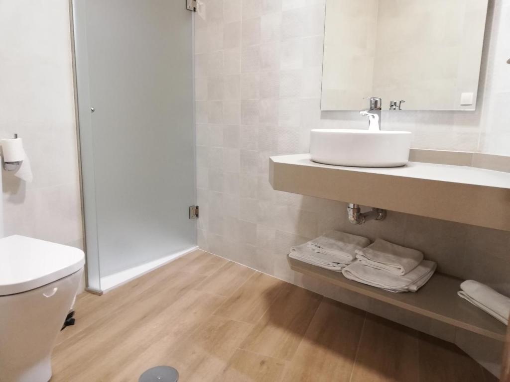 biała łazienka z umywalką i toaletą w obiekcie Hosteria de Rafi w mieście Priego de Córdoba