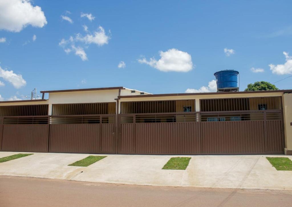 una casa con una valla marrón y un edificio en KITNET'S DA DENI, en Alto Paraíso de Goiás